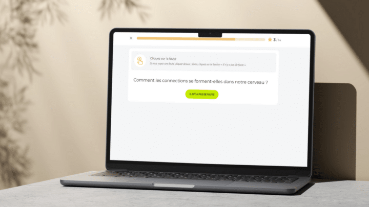 Un ordinateur portable posé sur une table affiche un exercice interactif du Projet Voltaire, invitant l’utilisateur à repérer une faute dans une phrase.